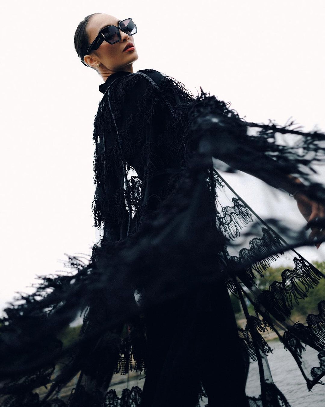 RBONNEY - MEGA R'Bonney Gabriel in an all-black ensemble, ,featuring a lacy, textured cape on her shoulders for Florentina Letner's show